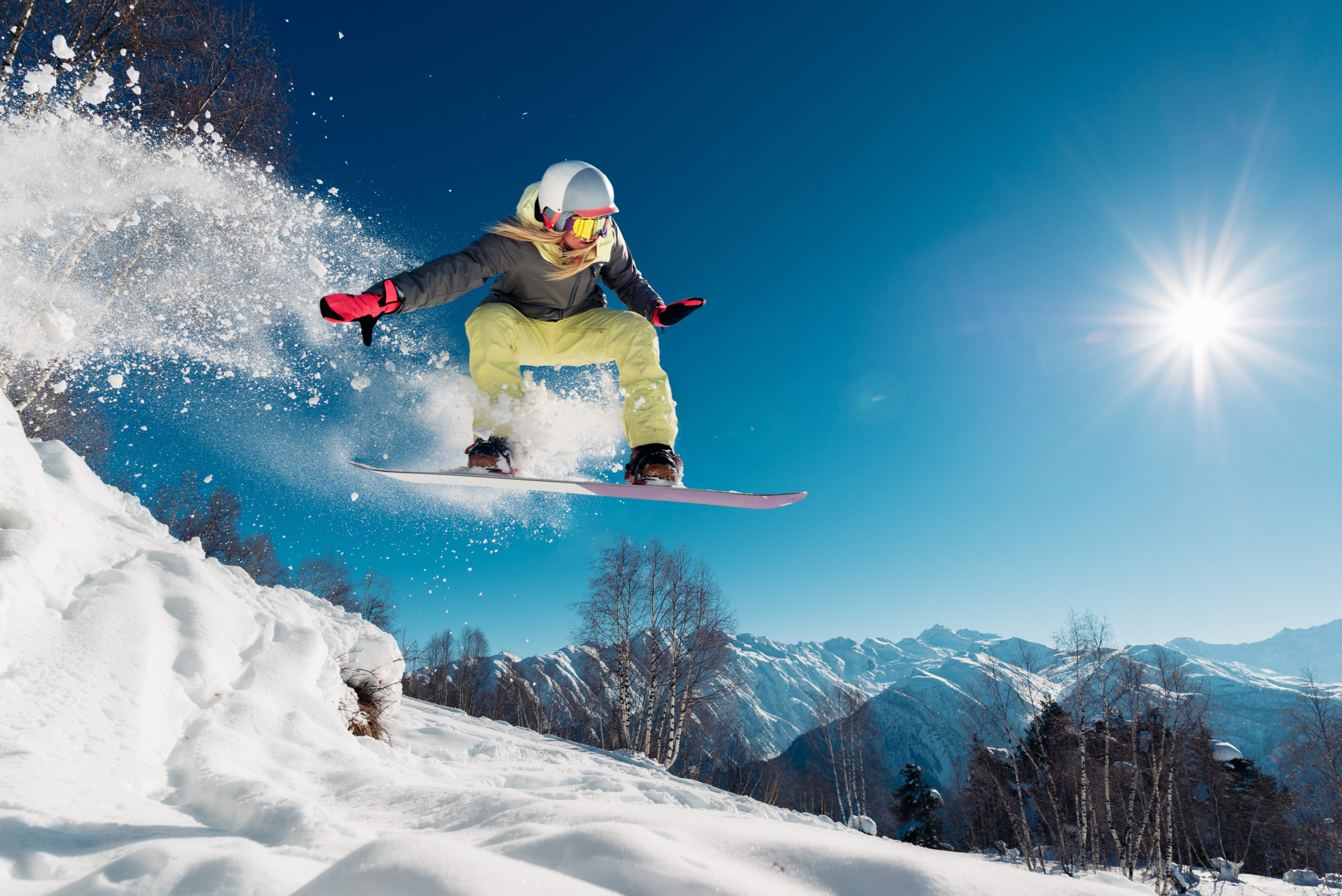 Girl is jumping with snowboard from the hill